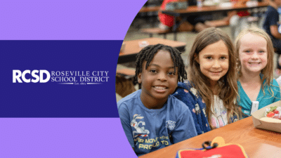 Picture of three young students at a lunch table with 