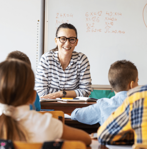 woman with glasses talking to her class of students